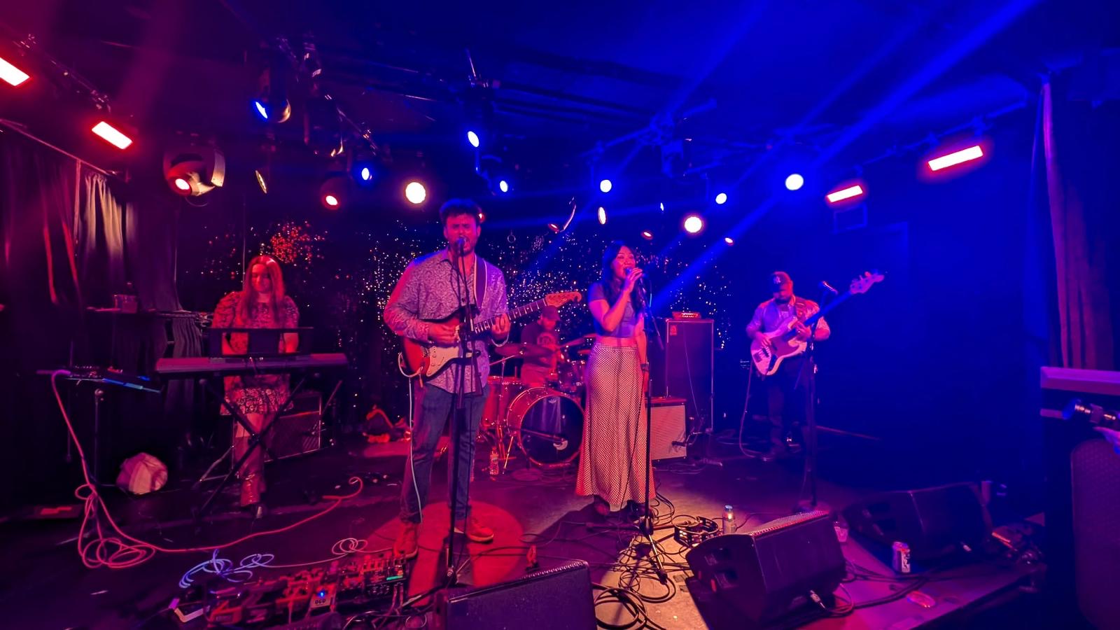 Good Time Mystery Vision performing under blue and red stage lights